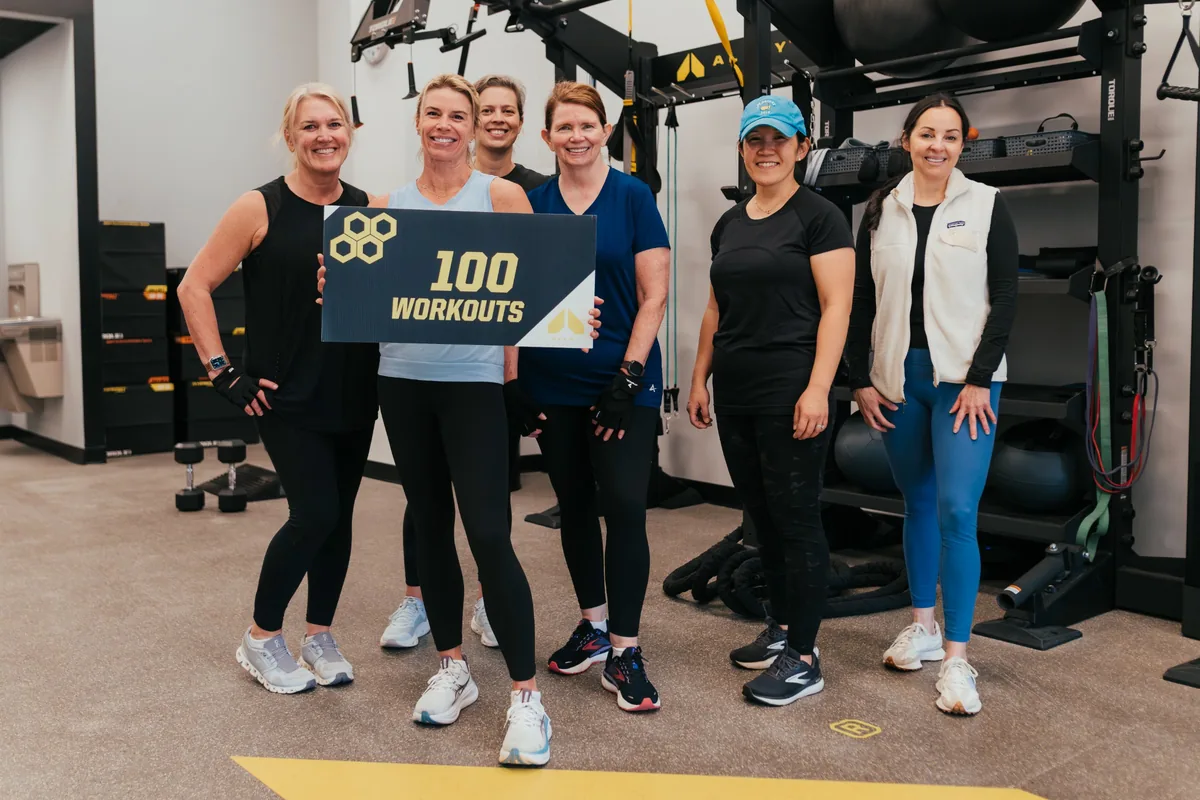 Small group of members celebrating 100 workouts together at Alloy Personal Training